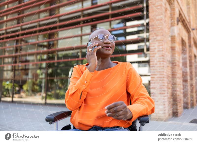 Black woman in wheelchair using phone outside modern building business black woman smartphone outdoor urban mobility accessibility disabled communication