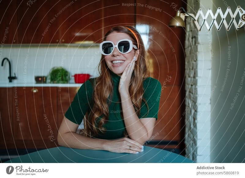 Comical 50s housewife wearing oversized sunglasses in kitchen woman vintage 1950s 50's cheerful looking at camera redhead retro concept fashion fun red hair