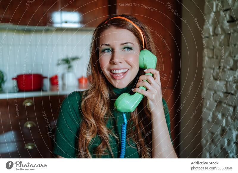 Retro housewife chatting on a vintage phone in a colorful kitchen woman redhead 1950s retro cooking cheerful talking communication telephone lively rotary green