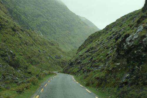 Narrow road through green mountainsides - mystical Ireland Street Slope Green Mystic Irish road trip trace Near Moss Grass rock travel Outdoors Picturesque