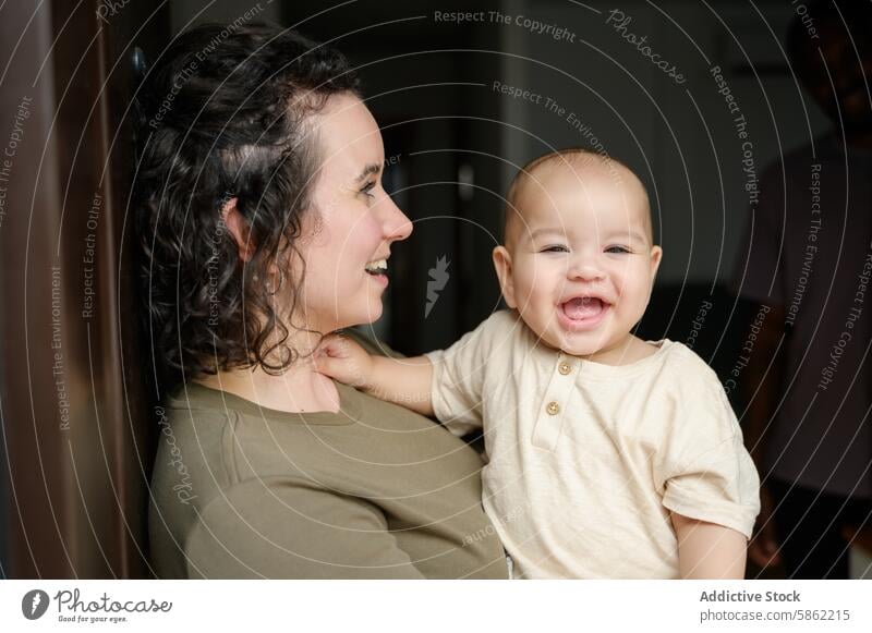 Multiracial family enjoying a playful moment at home multiracial multiethnic baby woman caucasian african american smile parent child toddler happiness