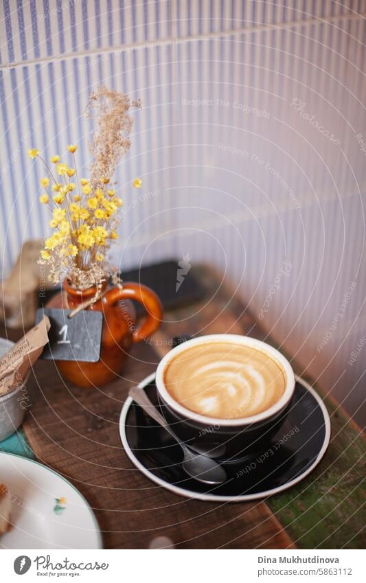 coffee cup cappuccino or flat white with latte art in a black cup on a wooden table at cafe. cozy cottage core cafe. Cappuccino cappuccino cup Coffee Cup Café