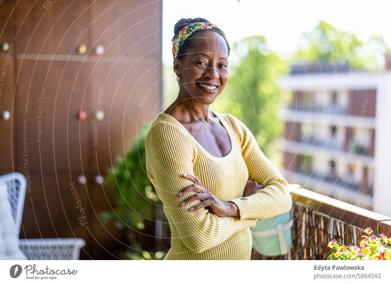 Portrait of smiling woman standing on the balcony at home people joy black natural attractive black woman happiness happy real people mature adult daily life