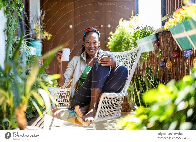 Beautiful woman relaxing on the balcony at home people joy black natural attractive black woman happiness happy real people mature adult daily life one person