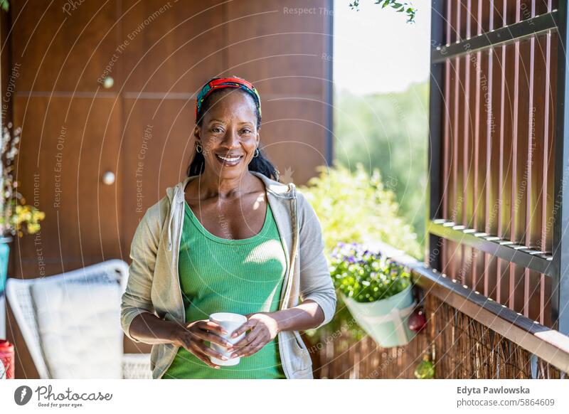 Portrait of smiling woman standing on the balcony at home people joy black natural attractive black woman happiness happy real people mature adult daily life