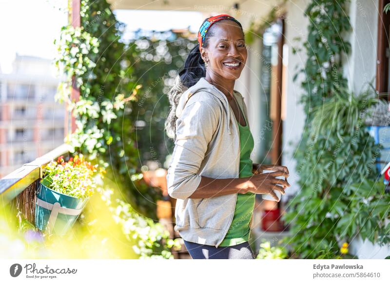 Portrait of smiling woman standing on the balcony at home people joy black natural attractive black woman happiness happy real people mature adult daily life