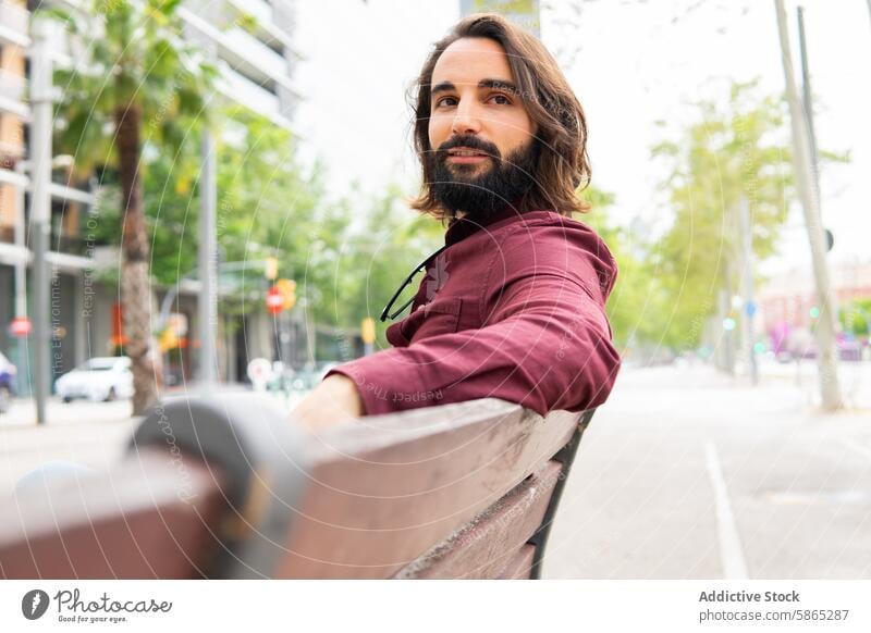 Man relaxing on a bench in Poblenou, embracing urban lifestyle man beard poblenou barcelona relaxation city casual street outdoor daytime young adult male