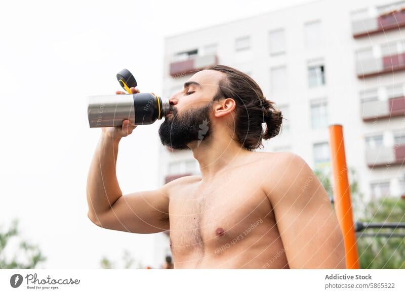 Man hydrating after workout in Poblenou, Barcelona man water bottle drinking outdoor exercise beard hydration fitness poblenou barcelona lifestyle health