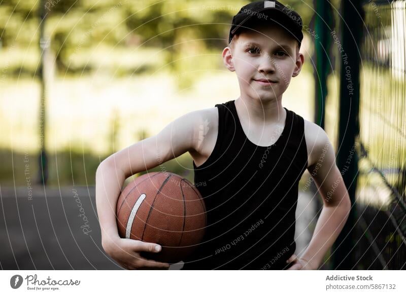 Young boy playing basketball outdoors in summer teenager sport youth athletic pose court green background blurred confidence moment athletic attire game child