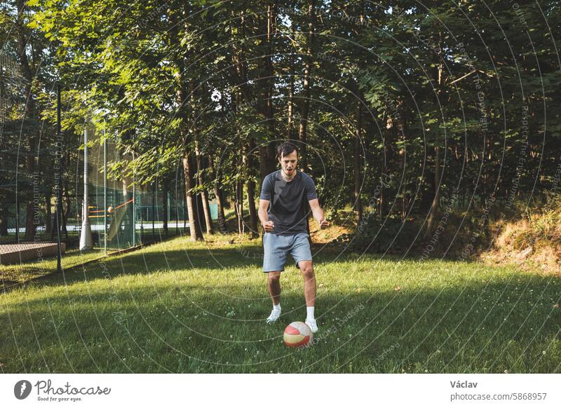 Black-haired athlete is enjoying success in football. Celebrating a winning match. Soccer player celebrates his winning goal excitement screaming determination