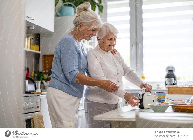 Happy senior woman with her adult daughter at home smiling happy enjoying positive contented people mature female elderly house old aging domestic life