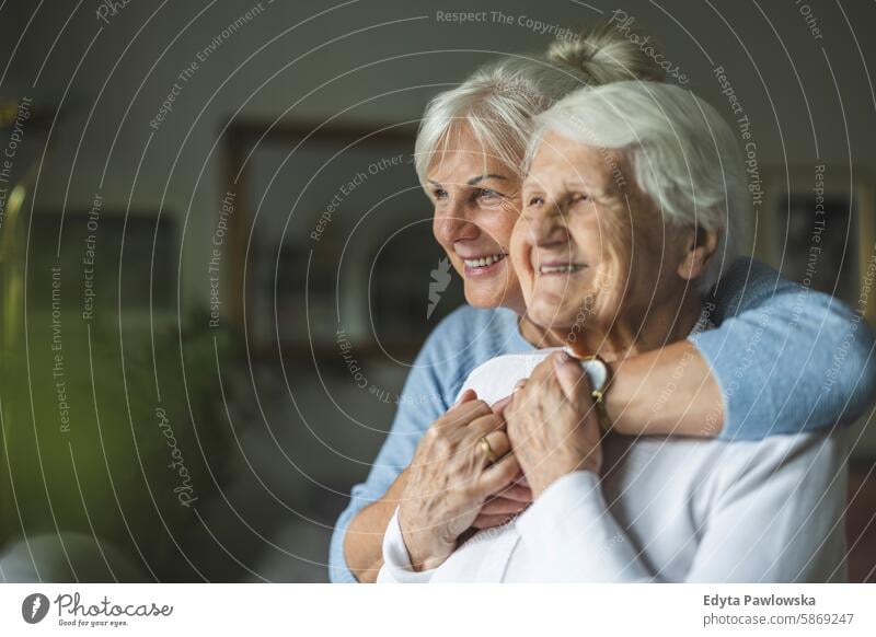 Happy senior woman with her adult daughter at home smiling happy enjoying positive contented people mature female elderly house old aging domestic life