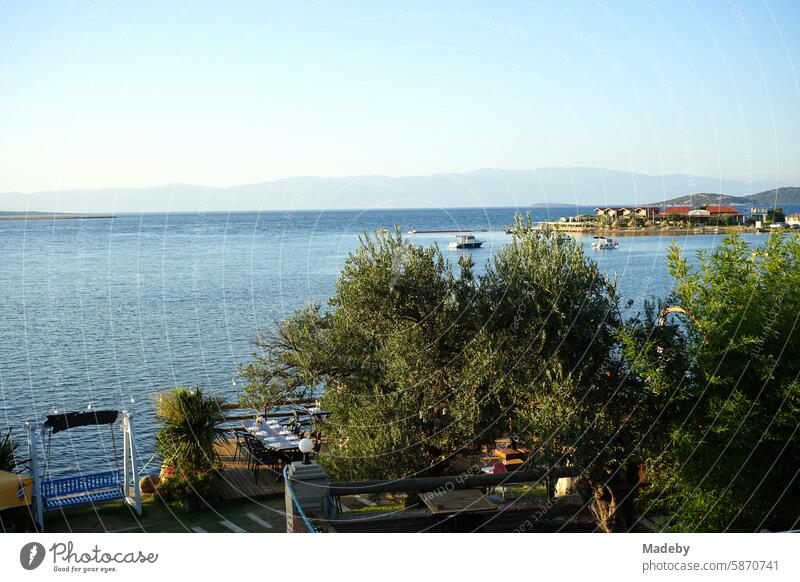 View from a bridge to the sea in the light of the evening sun with coastal landscape, bay and peninsula in Cunda near Ayvalik on the Aegean Sea in Balikesir province in Turkey