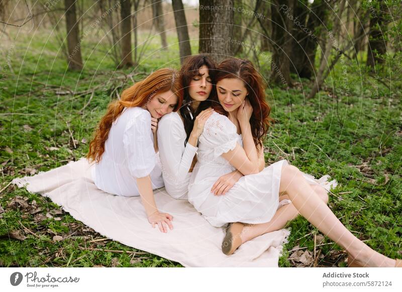 Three women relaxing together in a serene forest setting woman friend nature tranquil peaceful calm togetherness blanket sitting close lush greenery eyes closed