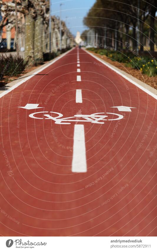 New marking bike path. White bicycle symbol and two oposite arrows on red asphalt lane, road. Bicycle path in the city. Two-way cycle lane on an avenue. Lifestyle. Urban traffic and transportation