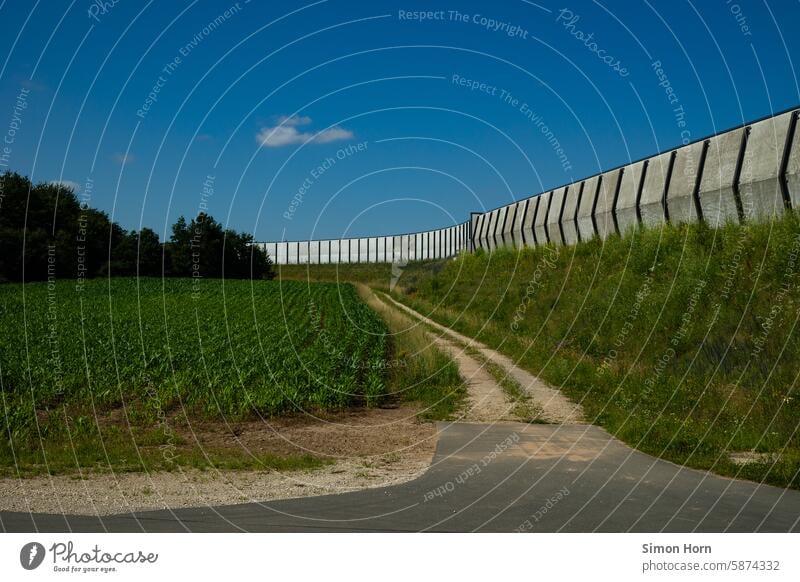 Large wall on an embankment along which a field path runs Wall (barrier) Border off the beaten track Wall (building) Divide Barrier Escarpment Border path