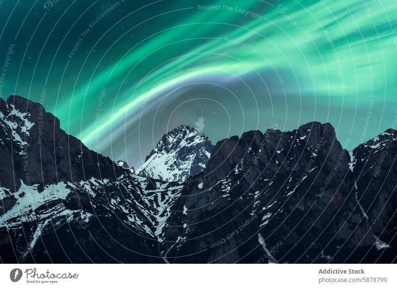 Spring Aurora over Snow-Capped Mountains aurora mountain spring snow night nature landscape sky green light borealis peak rugged dark snow-capped outdoor scene