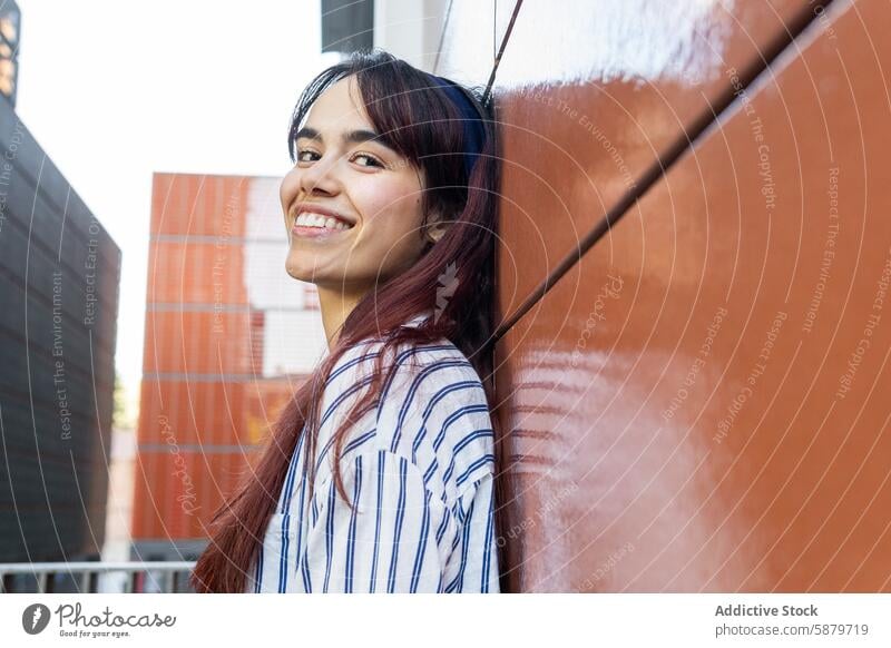 Happy young woman outdoors in a casual striped dress spring portrait smile youth vibrant happy lifestyle city urban fashion trendy modern contemporary beauty