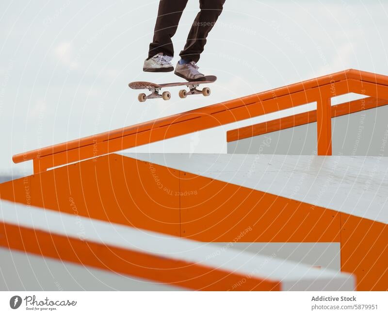 Skater Performing a Trick on Orange Skate Park Rail skateboarder jump skateboarding rail background grind manual person slide trick sport summer action riding