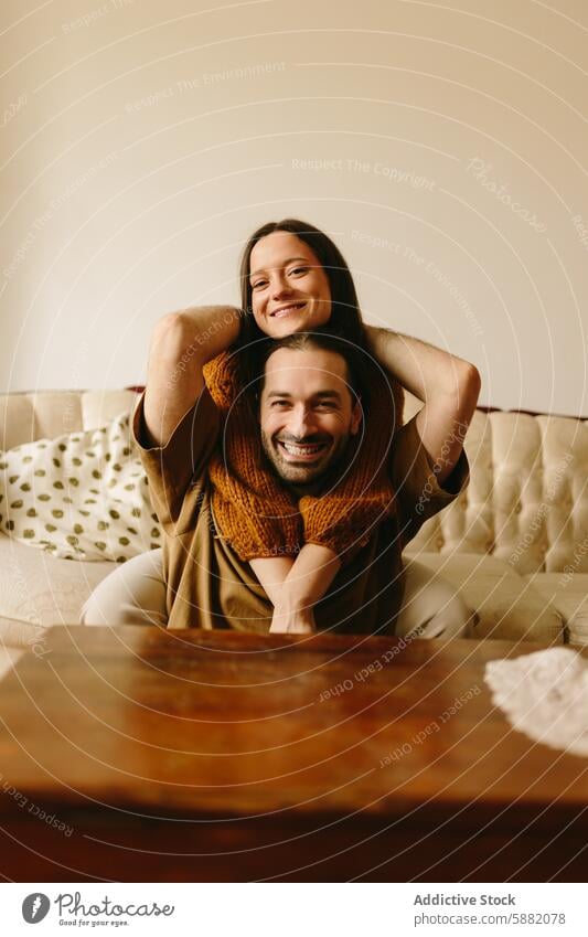 Cheerful couple indoors, woman sitting on man's shoulders joy play smile cheerful affection bond happiness leisure love relationship together casual home