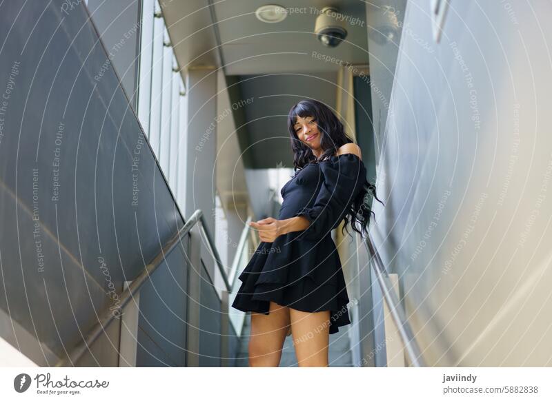 Woman in cute black summer dress dancing in urban stairs low angle sensual caucasian woman graceful elegant modern chic stylish confident dynamic movement