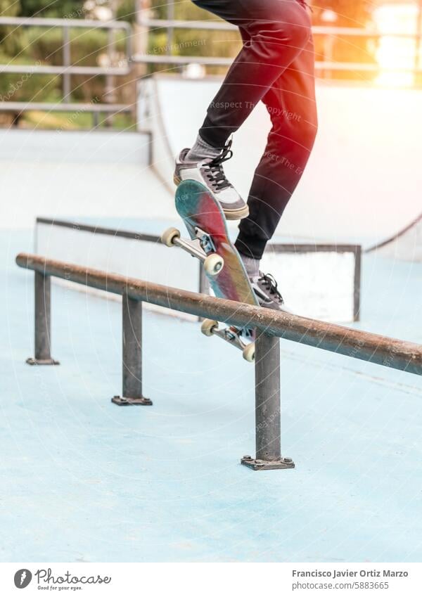 Skateboarder performing a trick on a rail at a skatepark. boy skateboarder skateboarding outdoor action sports recreation balance skill ramp jump grind athlete