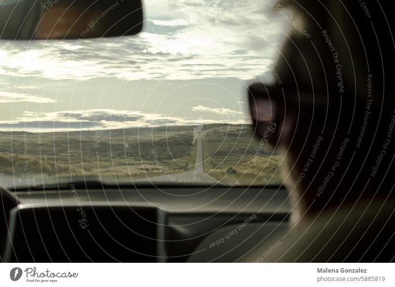 Silhouette of a woman from inside a car on a road trip, a road with mountains and greenery on the horizon roadtrip Green nature travel Vacation & Travel Nature