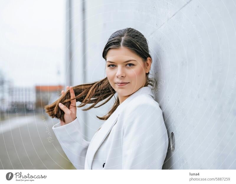 smiling young woman leaning against a wall Woman Smiling relaxed Young woman Meditative sensual Dreamily portrait fortunate youthful Happy Single optimistic