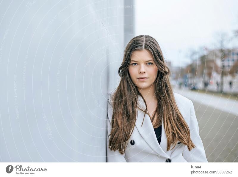 smiling young woman leaning against a wall Woman Smiling relaxed Young woman Meditative sensual Dreamily portrait fortunate youthful Happy Single optimistic