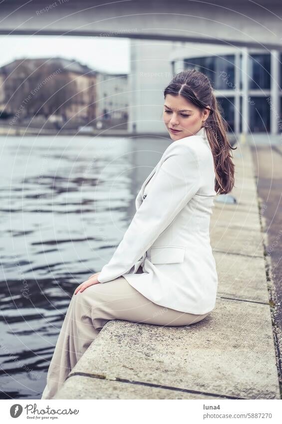 Thoughtful young woman sits by the river Woman Dreamily Smiling relaxed cheerful Laughter Young woman portrait fortunate youthful Happy Single optimistic