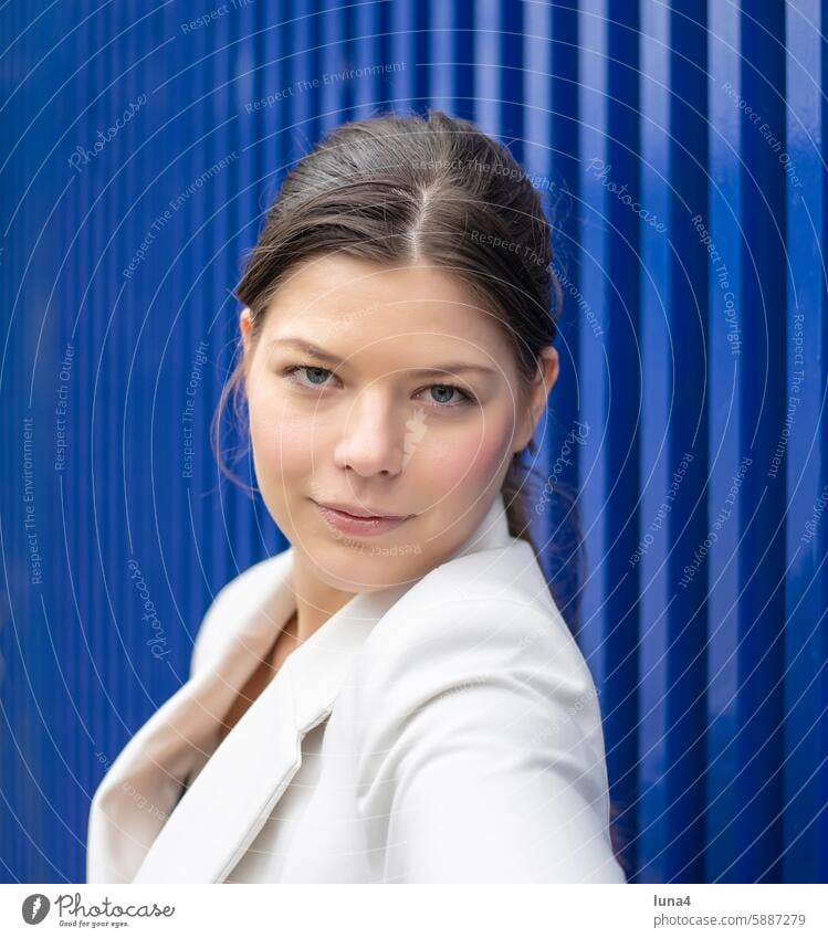 Smiling young woman against a blue background Woman relaxed Young woman Meditative sensual Dreamily portrait fortunate youthful Happy Single optimistic cheerful