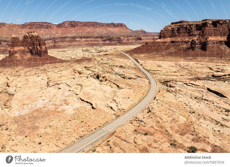 A winding road through the rugged landscape of White Canyon canyon desert arid scenic drive from above red rock formation sky blue clear natural beauty terrain