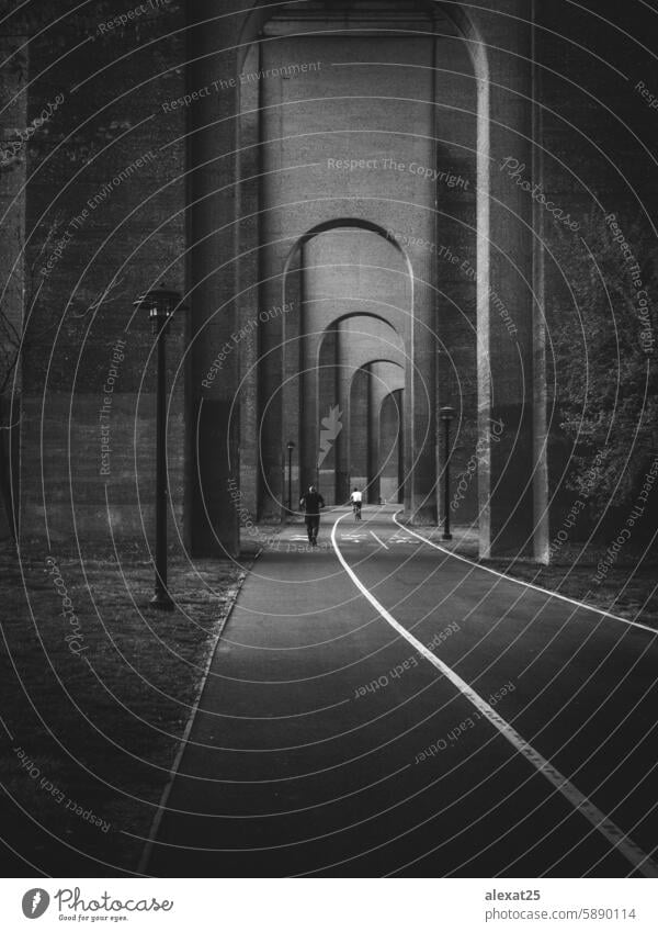 Image artistic in black and white of two people doing sport under arches Black & white photo Grayscale outdoors Vertical