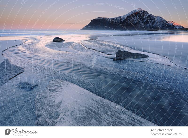 Winter twilight over frozen shore in Lofoten lofoten norway winter shoreline icy pastel sky mountain backdrop landscape nature tranquil serene dusk dawn outdoor