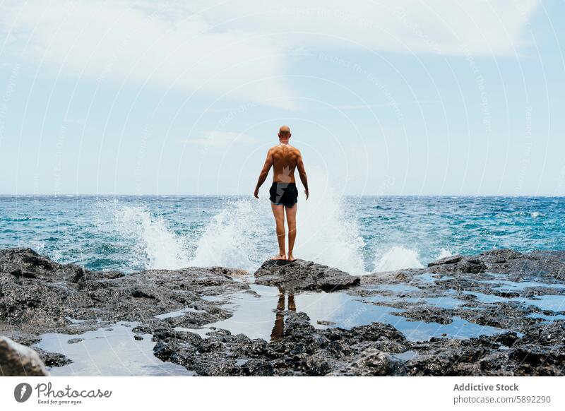 Man admiring the ocean waves from rocky shore summer holiday man freedom adventure travel sea vacation coastline water spray horizon nature outdoor scenic