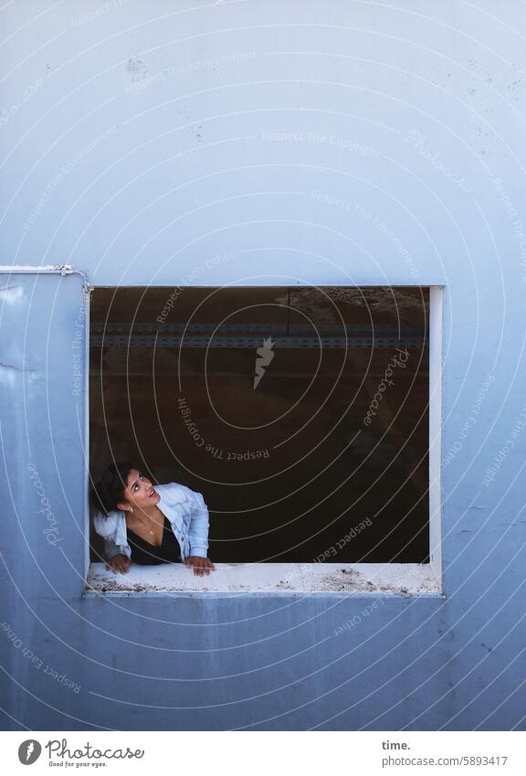 Woman in parking garage Upward Jacket Concrete Parking garage Window Blue test Observe portrait Looking Long-haired Feminine Jewellery Rest on Curiosity