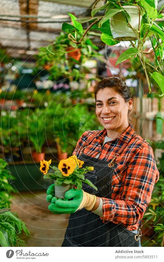 Smiling woman with potted flowers in greenhouse plant gardener smile positive botany flora female cheerful hobby bloom growth floral flowerpot worker natural