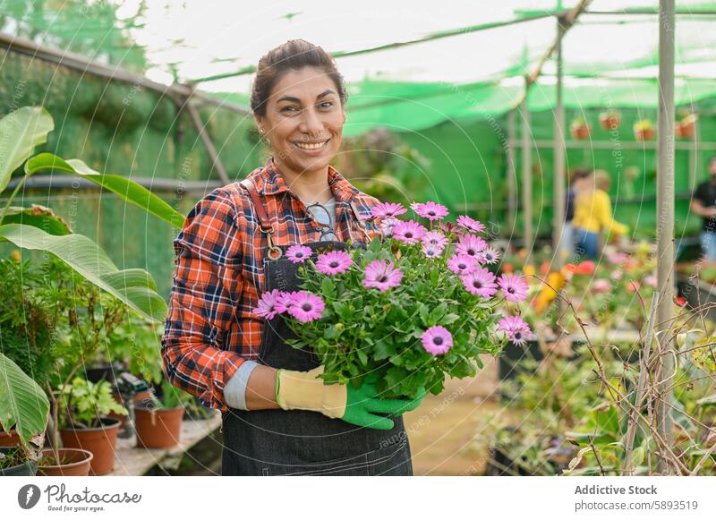 Cheerful gardener with bouquet of flowers woman smile greenhouse horticulture floral plant farmer female blossom bloom glove cultivate fresh natural cheerful