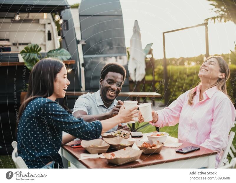 Happy people eating and cheering at food truck restaurant - Focus on african man face away bar beverage black chef city client coffee community customer dinner