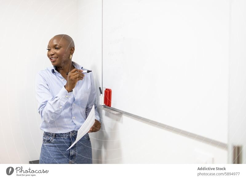 Engaged educator leading a lesson on a whiteboard classroom teacher teaching professional woman education learning marker paper workbook smiling engaged seminar