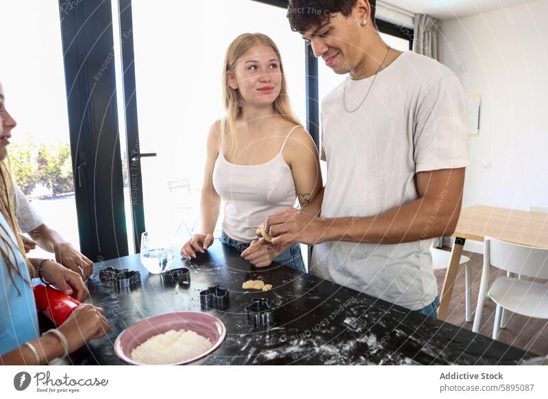 Family baking together in a modern kitchen cooking home family teamwork bond relationship cookie dough preparation casual lifestyle indoor cooking utensil flour