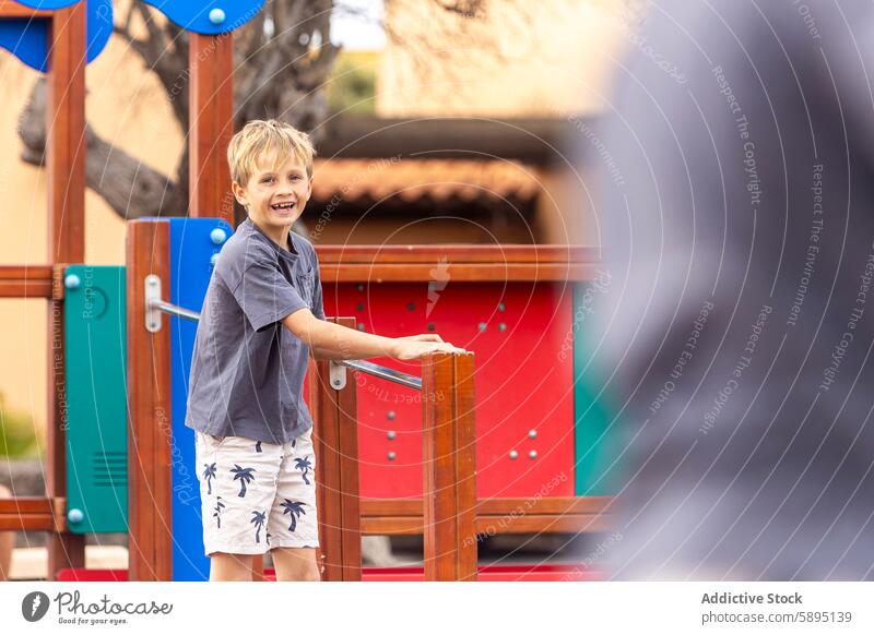 Young boy playing on a colorful playground structure child outdoor summer joyful happiness casual activity sunny day fun leisure park smile looking at camera