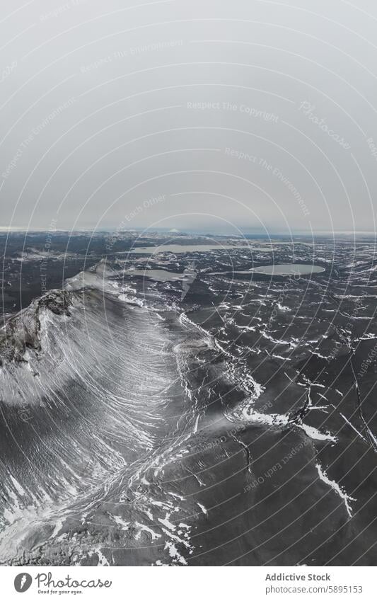 Aerial view of snow-covered mountain and lakes in the Icelandic Highlands iceland highland aerial view drone view winter cold landscape nature wilderness remote