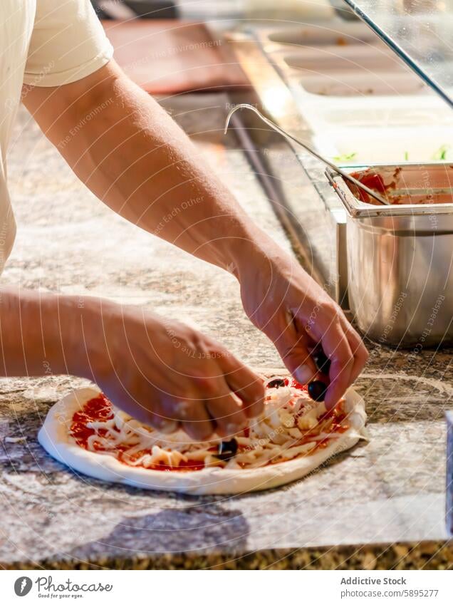 Hands preparing pizza with fresh toppings in kitchen preparation hand cheese sauce olive food cooking ingredient cuisine baking dough meal dinner lunch snack