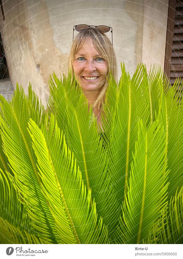 Woman's head over plant Smiling Foliage plant Happy fortunate Joy Adults Feminine pretty portrait Contentment naturally Happiness Laughter Face Optimism