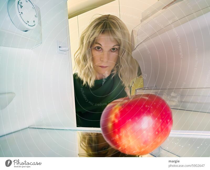 A hungry woman looks in the fridge Icebox Woman Empty Apple fruit salubriously Fresh Vitamin-rich Delicious Food Nutrition Organic produce Vegetarian diet Diet