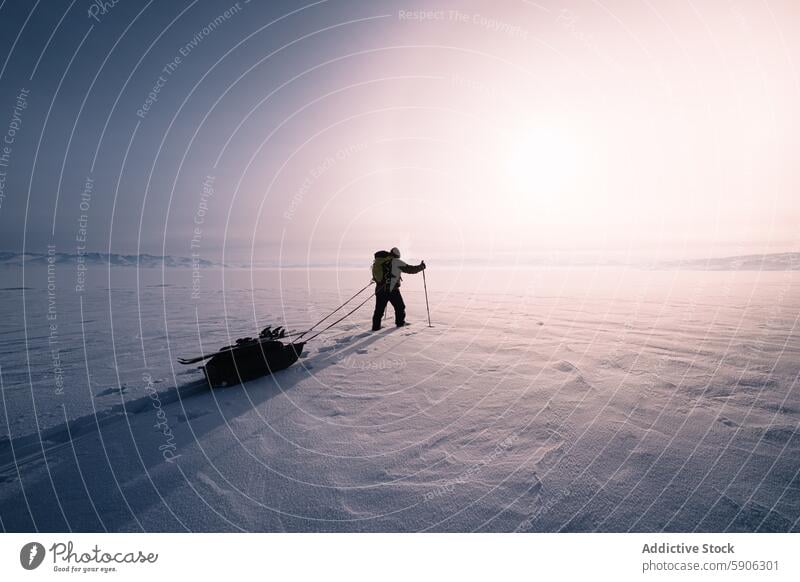 Explorer pulling sled across snow-covered landscape in Kyrgyzstan explorer kyrgyzstan mountain daylight trekking serene winter adventure outdoor journey cold