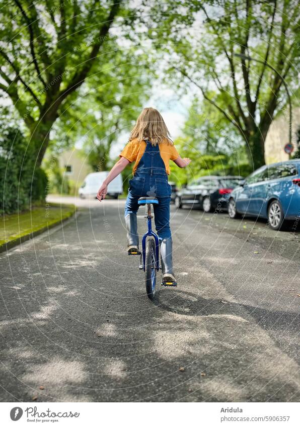 Child riding a unicycle on the road Unicycle Bicycle Driving Girl Cycling Infancy Mobility Lanes & trails Street Movement Leisure and hobbies Athletic Wheel