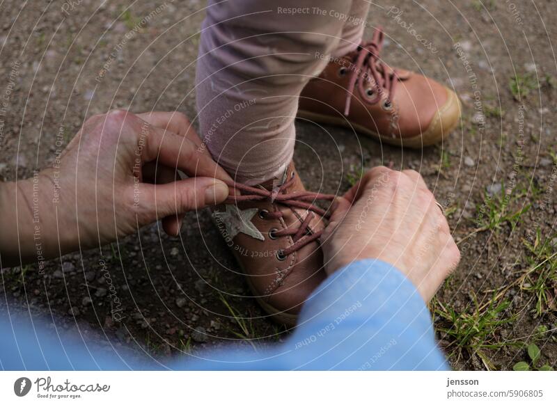 Close-up of hands tying small children's shoes Hand Footwear Tying your shoes shoelaces Childrens shoe Close-up view under natural lighting conditions Detail