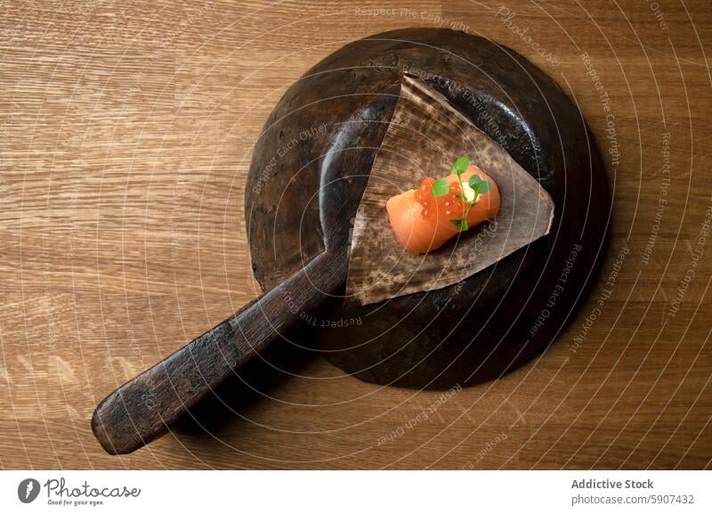 Sushi preparation in an old container sushi salmon wooden rustic traditional aged food presentation culinary cuisine japanese fish slice roe red green leaf